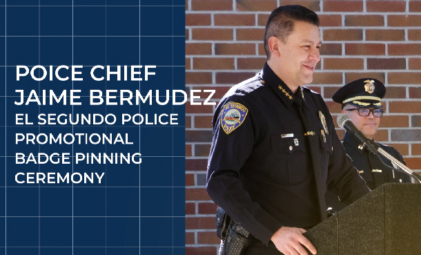 Chief Bermudez at podium with text on screen about badge pinning ceremony